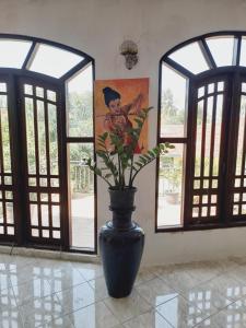 卡图纳耶克Moon Deck Villa的窗户房间里装有鲜花的黑色花瓶