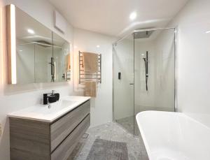 金德拜恩团圆公寓的白色的浴室设有水槽和淋浴。