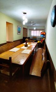 伊瓜苏港Casa Yvy Pytã的客厅设有一张大木桌和长凳