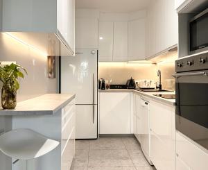 金德拜恩团圆公寓的厨房配有白色橱柜和冰箱。