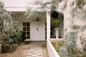 清迈爱宁曼精品酒店的白色的前门,有植物的房子
