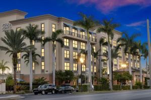 蓬塔戈尔达蓬塔戈尔达海港福朋喜来登酒店的一座棕榈树环绕的大建筑