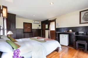 高兰穆克兰达生态度假酒店的卧室配有一张白色大床和一张书桌