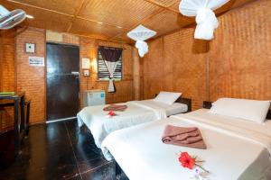 高兰穆克兰达生态度假酒店的一间设有三张鲜花的床的房间