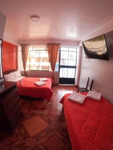 奥克萨潘帕Hospedaje Piura的酒店客房设有两张床和窗户。