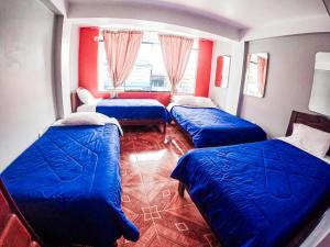 奥克萨潘帕Hospedaje Piura的客房设有3张蓝色的床和窗户。