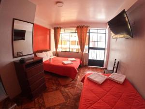 奥克萨潘帕Hospedaje Piura的小房间设有两张床和镜子
