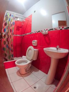 奥克萨潘帕Hospedaje Piura的红色的浴室设有卫生间和水槽