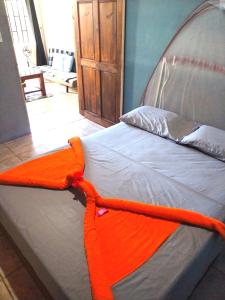希门尼斯港Anluka-House的床上有橙色毯子
