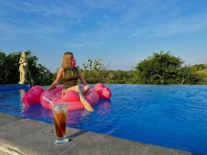 珀尼达岛Innora Jungle Resort And Spa的坐在游泳池里充气木筏上的女人