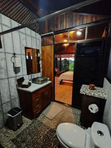 ChachaguaPitangus Lodge的一间带卫生间和水槽的浴室以及一间卧室