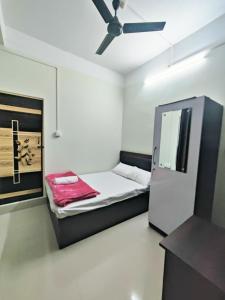 TezpurJM Suites的小房间设有一张床和一个吊扇