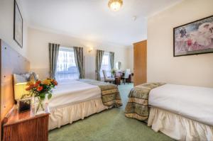 大雅茅斯The Dolphin Hotel的酒店客房设有两张床和一张桌子。