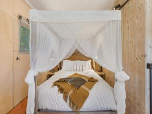 MarongBIG4 Bendigo Marong Holiday Park的卧室配有带白色窗帘的天蓬床