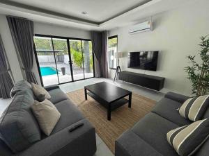 高兰Private poolvilla Koh Lanta的客厅配有沙发和桌子
