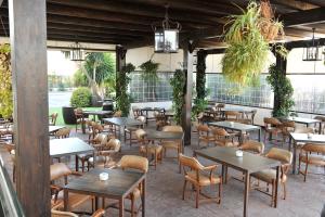安特克拉罗桑洛酒店的一间设有桌椅的餐厅,种植了植物