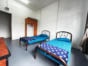 乌鲁地南Jiaxin Dormitory - Puteri Wangsa 家馨旅舍的一间客房内配有两张床的房间