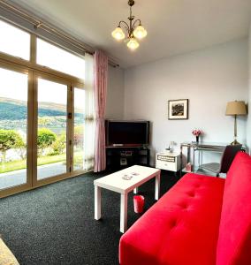 皇后镇Kelvin Garden Villa的客厅配有红色沙发和电视
