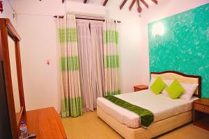 卡图纳耶克Ared Villa的一间卧室配有一张带绿色枕头的床