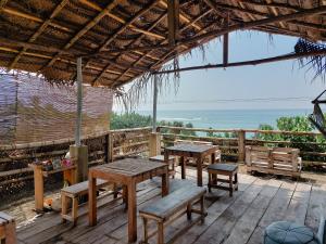 阿杭格默Gaia Ocean Surf Yoga的一个带桌子和长椅的海景庭院