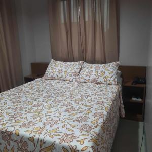 BoronganLorraine Suites的卧室内的一张床位,配有床罩和枕头