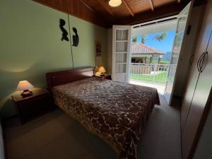 坎波斯杜若尔当Recanto Habacuque的一间卧室设有一张床和一个大窗户