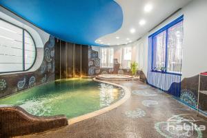里加Cozy house with sauna, pool and private garden的蓝色天花板客房中的游泳池
