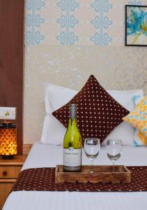 马拉里Hotel Hadimba Manali By YB Hotels的床上有一瓶葡萄酒和两杯酒