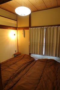 会津若松末廣宿(女性専用)- suehirojyuku for woman- by mooi的一间卧室设有一张大床和一个窗户。