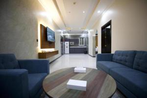 利雅德علم الفريدة للوحدات السكنية المفروشة Alam Faridah Hotel的客厅配有2张蓝色的沙发和1张桌子
