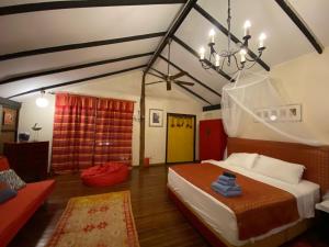 立咯海滩体验岛文化遗址度假屋的一间卧室配有一张床和一个吊灯