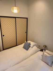 京都Imakumano Terrace - Eisen An 潁川庵的两张睡床彼此相邻,位于一个房间里