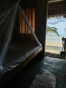 爱妮岛Bucana Beach Camp的海滩景客房的一张床位