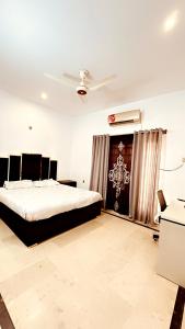 拉瓦尔品第QueensLand villa near Islamabad airport & motorway的一间卧室设有一张床和天花板