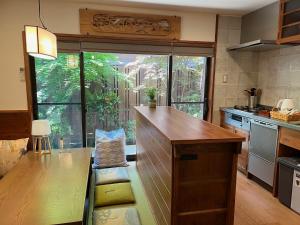 京都Imakumano Terrace - Dohachi An 道八庵的厨房设有木制柜台和大窗户。