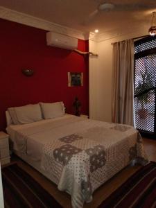 卢克索Villa Quiet Place的一间卧室设有一张红色墙壁的大床