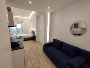 雅典Minimal Athens Apartment的一间带蓝色沙发的客厅和一间厨房