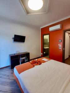 圣马力诺Rainbow Hotel Depandance Joli的一间卧室配有一张大床和电视