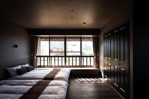 ItoshimaItoshima810 Villa & Resort - Vacation STAY 13917的一张位于带大窗户的房间内的床铺