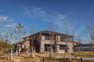 ItoshimaItoshima810 Villa & Resort - Vacation STAY 13917的前面有树木的建筑