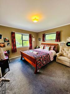 汉密尔顿Dora's Comfortable Homestay in Hamilton的一间卧室配有一张床、一张沙发和一把椅子