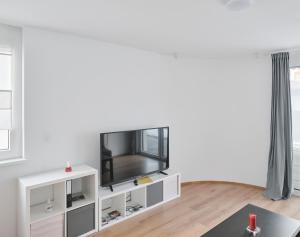 瓦滕斯Wohnen in Wattens Top 3的一间客厅,在白色架子上配有电视