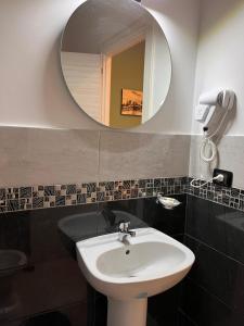 那不勒斯Oceania Hotels Napoli的一间带水槽和镜子的浴室