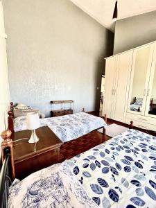 内罗毕Westlands Escape-Homestay的一间卧室配有两张床和一张带台灯的桌子