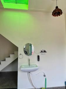 瓦拉纳西Kashi Village Home Stay的浴室设有水槽和墙上的镜子