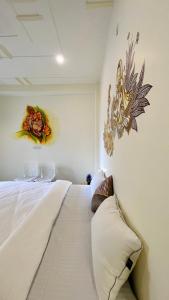 瓦拉纳西Kashi Village Home Stay的卧室配有一张大白色床,墙上挂着鲜花