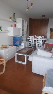 圣维森德马尔Estupendo apartamento en San Vicente do Mar O Grove的客厅配有白色家具和桌子