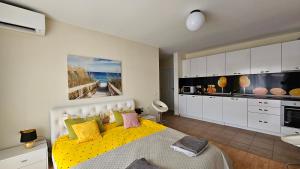 阳光海滩2 Zimmer Wohnung的一间带黄色床的卧室和一间厨房