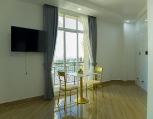 金边Try Residence, The Elysée Koh Pich的一间带桌椅和大窗户的用餐室