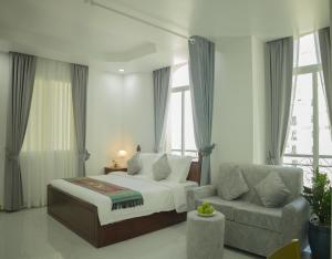 金边Try Residence, The Elysée Koh Pich的一间卧室配有一张床、一张沙发和窗户。